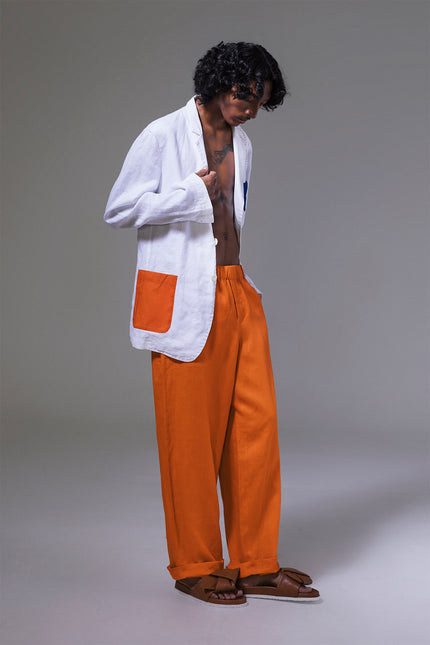 Model wearing Mackenzie Jacket in pure linen, featuring a slim structured silhouette, indigo and tangerine pockets, and hand-stitched detailing.