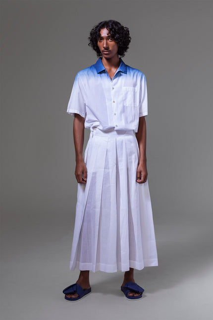 Model wearing cotton camp shirt with natural indigo dip-dye at the top, featuring short sleeves, side slits, and open collar.
