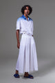 Model wearing cotton camp shirt with natural indigo dip-dye at the top, featuring short sleeves, side slits, and open collar.