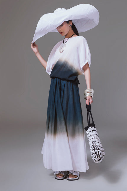 Model wearing the Matrena Top in lightweight cotton, featuring a relaxed silhouette with boat neckline, softly gathered sleeves, indigo dip-dye effect, and adjustable drawstring hem for versatile styling.