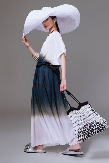 Model wearing the Matrena Top in lightweight cotton, featuring a relaxed silhouette with boat neckline, softly gathered sleeves, indigo dip-dye effect, and adjustable drawstring hem for versatile styling.