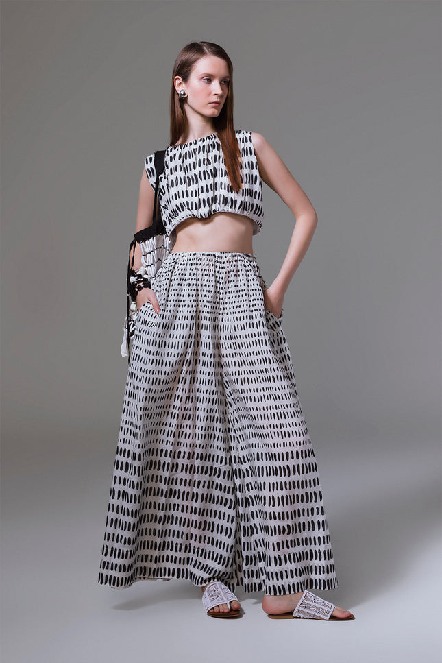 Model wearing Mette Pants with wide flowing legs, elastic waistband, side pokets, and gradation stone print.