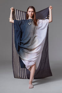 Model wearing black, grey, and white ombré cotton dress with front drape and relaxed silhouette.