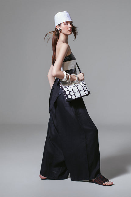 Model wearing Madeon Pants in lightweight linen with low-crotch silhouette, drawstring waist, and draped skirt-like effect.
