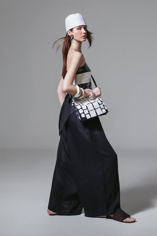 Model wearing Madeon Pants in lightweight linen with low-crotch silhouette, drawstring waist, and draped skirt-like effect.