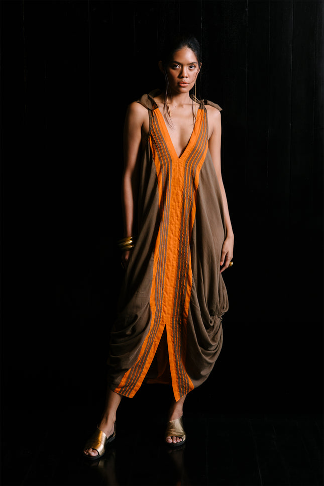 Model wearing Jaeden Dress in lightweight cotton, featuring tie shoulder straps, a reversible design, knotted hem detailing, and a central slit.