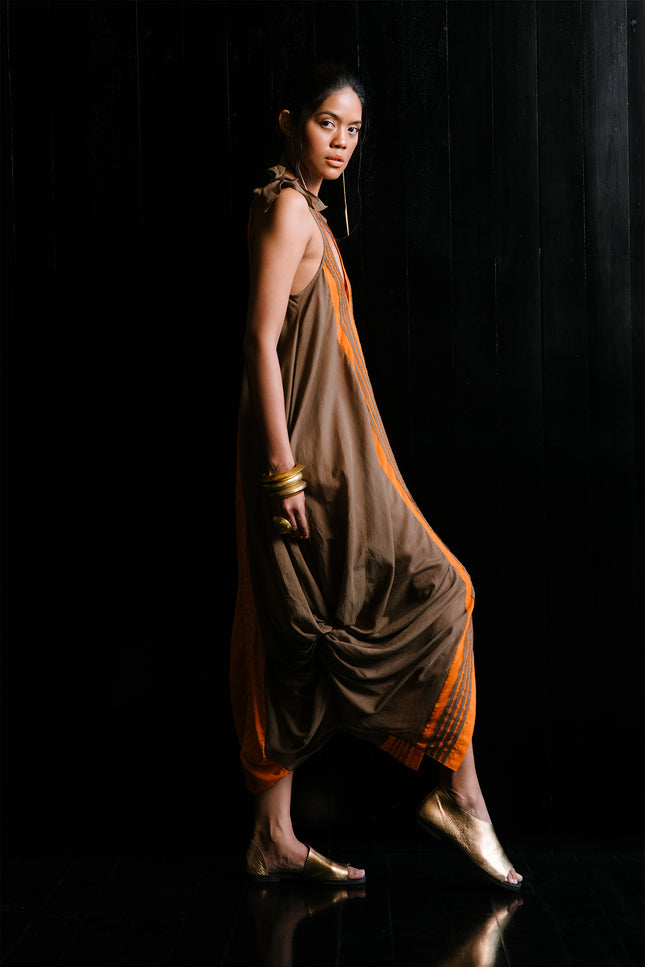 Model wearing Jaeden Dress in lightweight cotton, featuring tie shoulder straps, a reversible design, knotted hem detailing, and a central slit.