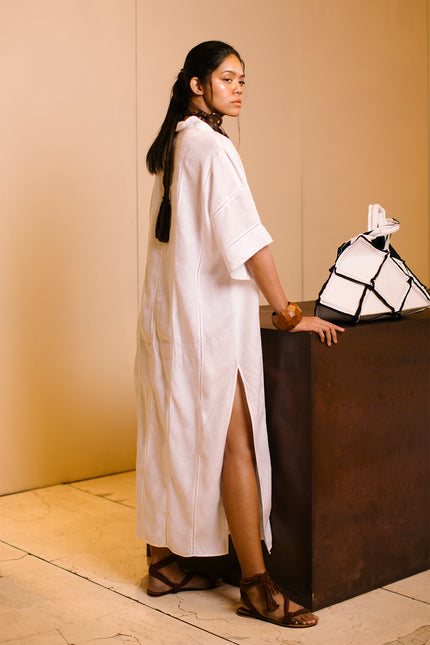 Model wearing Lenore Kaftan in linen, featuring relaxed kimono sleeves, deep V-neckline, high side slits, and delicate fagoting details.