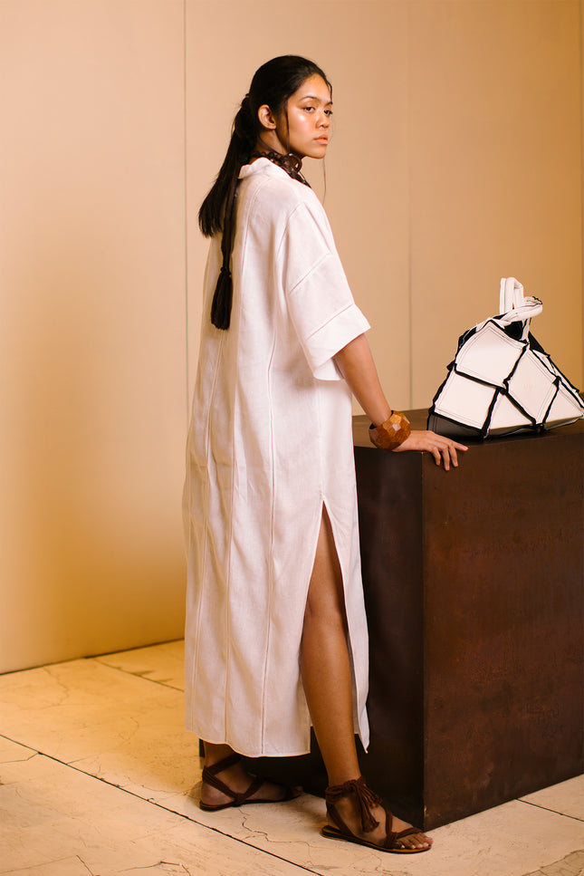 Model wearing Lenore Kaftan in linen, featuring relaxed kimono sleeves, deep V-neckline, high side slits, and delicate fagoting details.