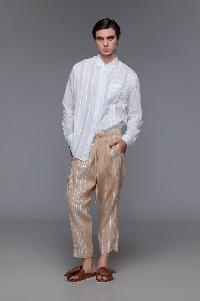 Model wearing white collared shirt with wrist cuffs, button placket, and tonal linen-cotton patchwork details.