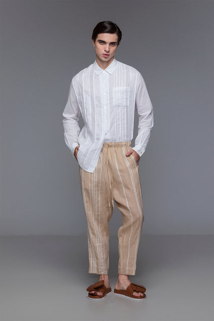 Model wearing white collared shirt with wrist cuffs, button placket, and tonal linen-cotton patchwork details.