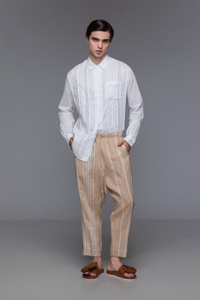 Model wearing white collared shirt with wrist cuffs, button placket, and tonal linen-cotton patchwork details.
