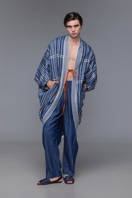 Model wearing Marlie Outer in cotton with diamond-shaped silhouette, satin ribbon applique, and ribbon fastening.