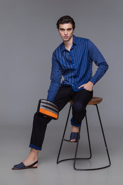 Canvas pouch with bold tarpaulin stripe appliqué, zipper closure, contrast handle, and internal mesh pocket.