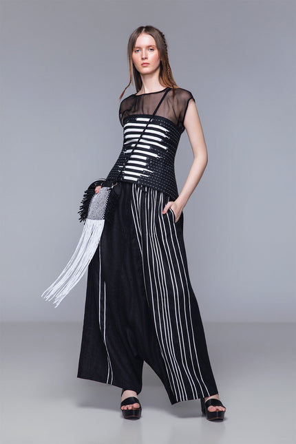 Model wearing Matana Corset in pure cotton with adjustable back tail and strap closure, featuring monochrome ribbon detailing and contrast hand stitching for a refined statement look.