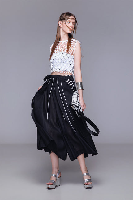 Model wearing Netta Cropped Top handcrafted with macrame, featuring a diamond net structure, sleeveless one-size silhouette, and open-knit design for textured layering.