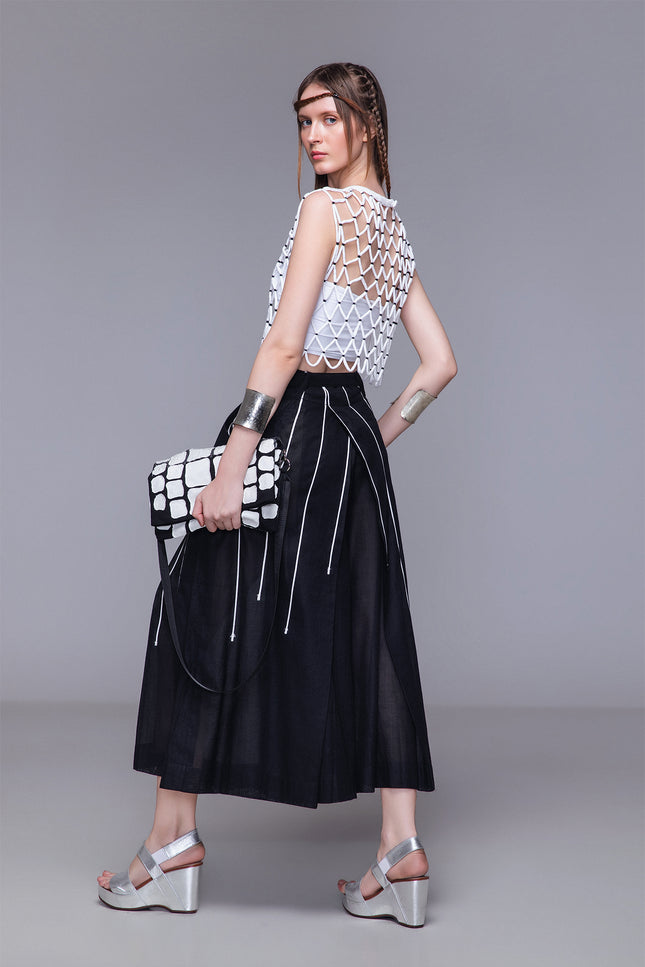 Model wearing Netta Cropped Top handcrafted with macrame, featuring a diamond net structure, sleeveless one-size silhouette, and open-knit design for textured layering.