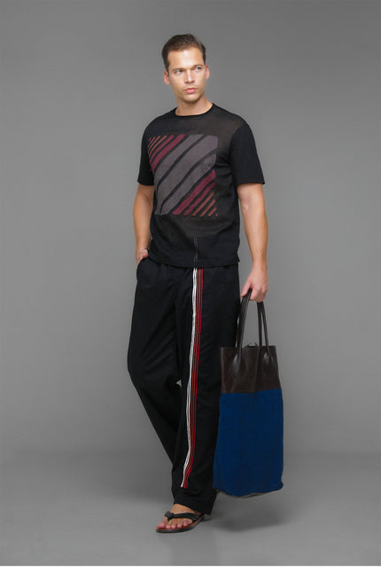 Model wearing Black Marko T-Shirt with short sleeves, round neckline, square striped applique, and contrast fabric details.