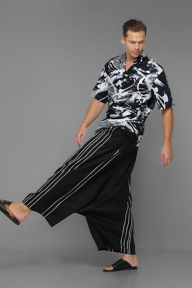 Model wearing Moshe Shirt in pure cotton with an oversized silhouette, black-and-white batik splash pattern, and open notch-lapel collar for relaxed warm-weather styling.