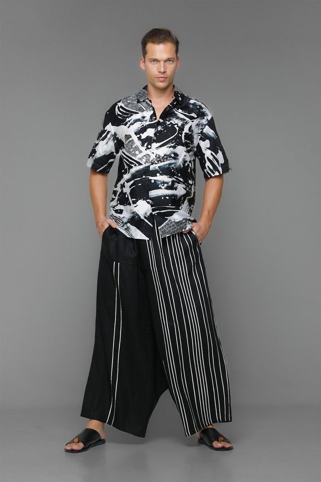 Model wearing Moshe Shirt in pure cotton with an oversized silhouette, black-and-white batik splash pattern, and open notch-lapel collar for relaxed warm-weather styling.