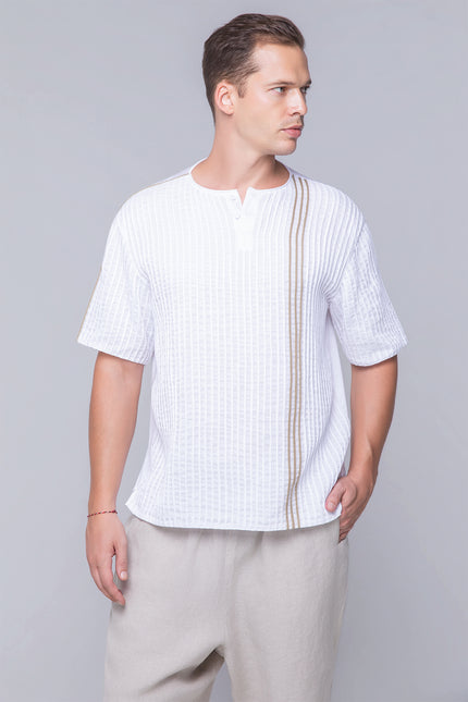 Model wearing the oversized Naman T-Shirt in pure cotton with a round neckline, invisible henley plamet, rolled applique, and dual-fabric contrast, designed for breathable comfort and modern style.