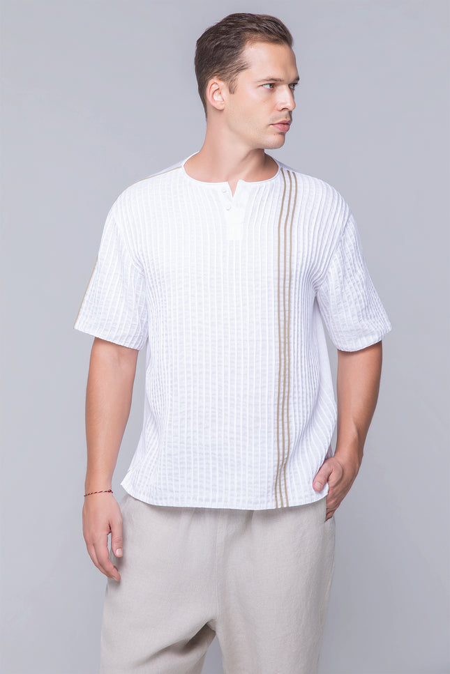 Model wearing the oversized Naman T-Shirt in pure cotton with a round neckline, invisible henley plamet, rolled applique, and dual-fabric contrast, designed for breathable comfort and modern style.
