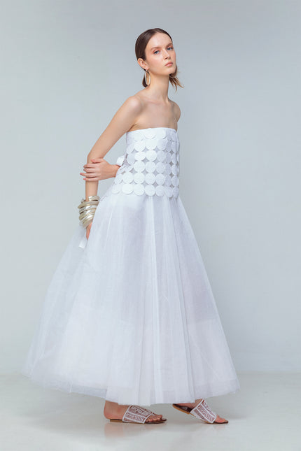 Model wearing white linen tube top made from coin-shaped appliques with ribbon tie closures.