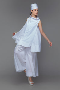 Model wearing cotton mini dress with cowl neck in sleek white.