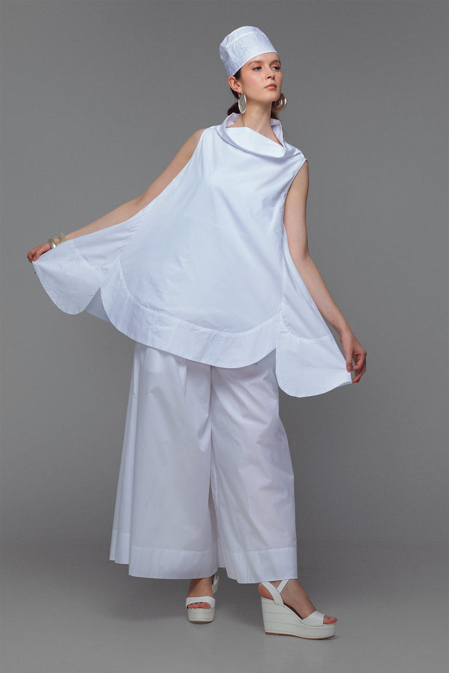 Model wearing cotton mini dress with cowl neck in sleek white.
