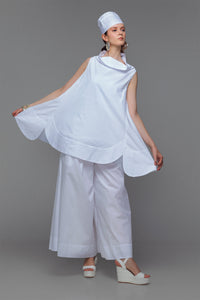 Model wearing cotton mini dress with cowl neck in sleek white.