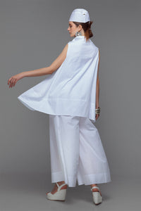 Model wearing cotton mini dress with cowl neck in sleek white.