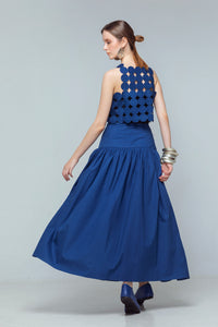 Model wearing indigo linen crop top with coin-shaped appliqués, styled with a high-waisted gathered skirt.