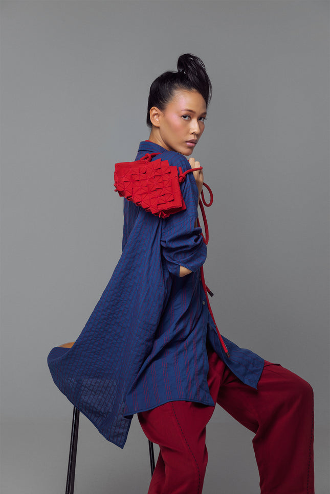 Model wearing oversized long-sleeve shirt dress with full vertical buttons, styled as a casual yet polished tunic.