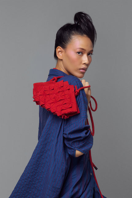 Nemesia Mini Sling Bag made from cotton with origami-inspired geo flower appliqué, featuring a detachable spaghetti strap for crossbody or handheld use.