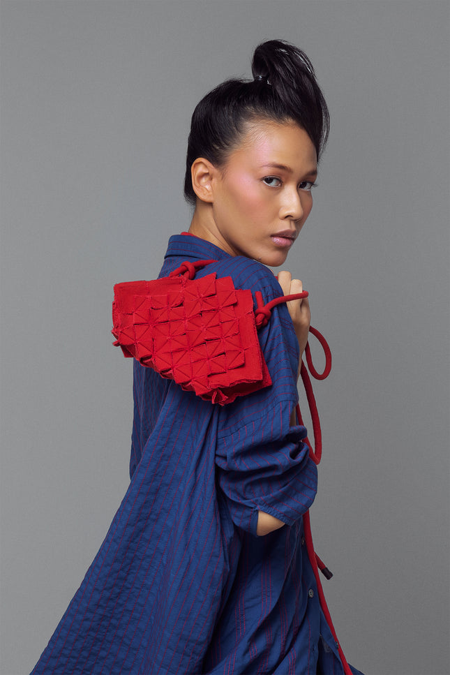 Nemesia Mini Sling Bag made from cotton with origami-inspired geo flower appliqué, featuring a detachable spaghetti strap for crossbody or handheld use.