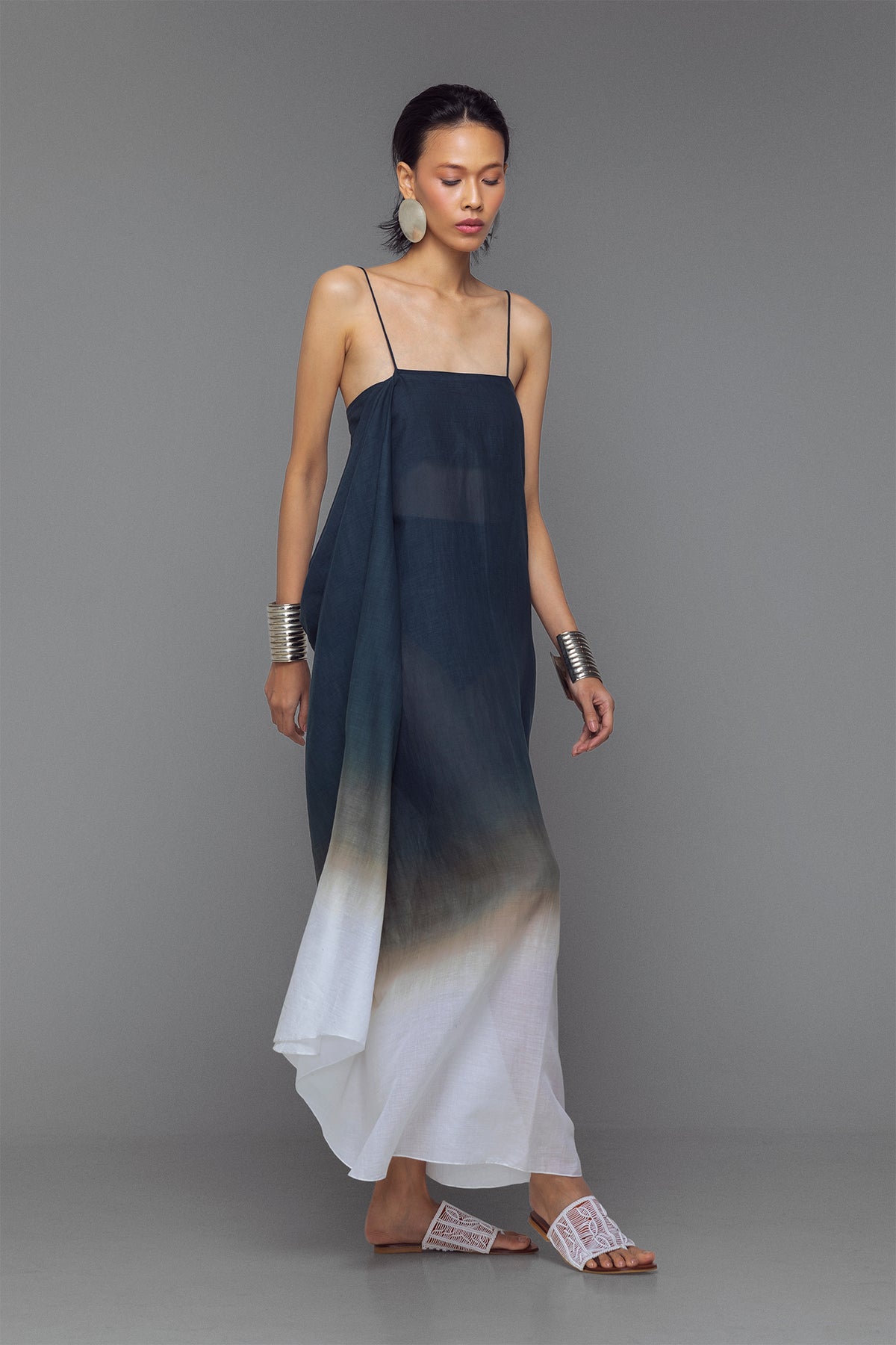 Model wearing black and white dip-dye cotton dress with criss-cross straps and flowy adjustable silhouette.
