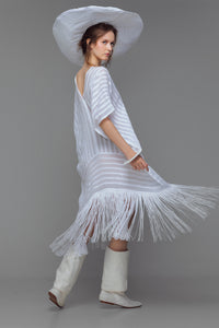 Model wearing white cotton kaftan with stripe appliqué and handmade fringe, styled for summer.