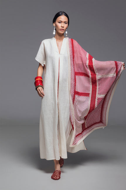 Model wearing Odis Kaftan in pure linen, featuring a loose silhouette with clean lines, V-neckline, side slit, contrast binding, and neutral palette, perfect for a relaxed resort wear.