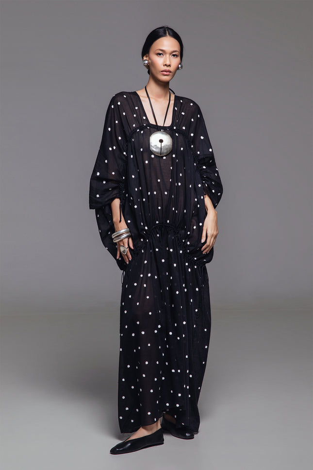 Model wearing Olivine Kaftan in lightweight cotton with relaxed silhouette, adjustable front drawstrings, square neckline, and timeless polka dot print.