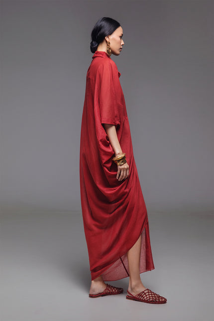 Model wearing Ozella Kaftan with contemporary silhouette, high neckline, sculptural drapery, and contrasting asymmetrical hem for a sophisticated look.