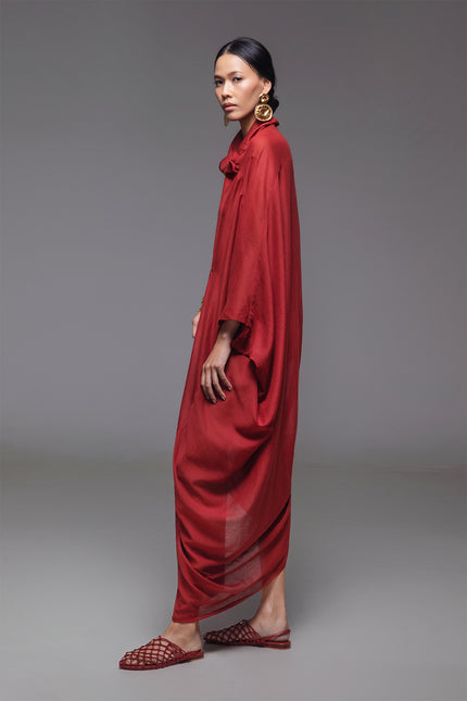 Model wearing Ozella Kaftan with contemporary silhouette, high neckline, sculptural drapery, and contrasting asymmetrical hem for a sophisticated look.