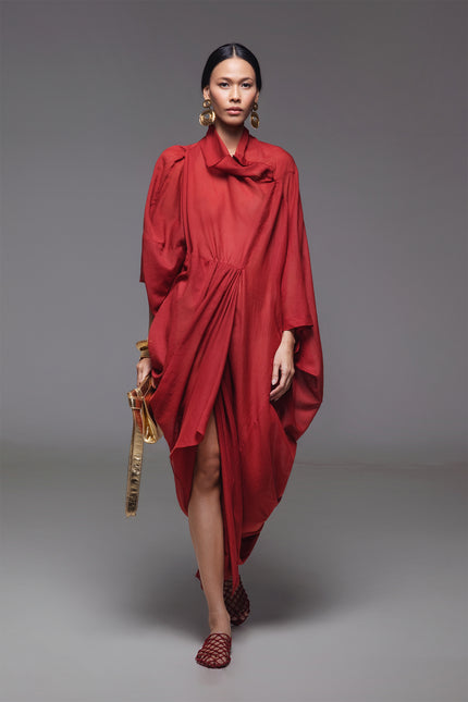 Model wearing Ozella Kaftan with contemporary silhouette, high neckline, sculptural drapery, and contrasting asymmetrical hem for a sophisticated look.