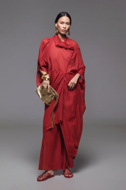 Model wearing Ozella Kaftan with contemporary silhouette, high neckline, sculptural drapery, and contrasting asymmetrical hem for a sophisticated look.