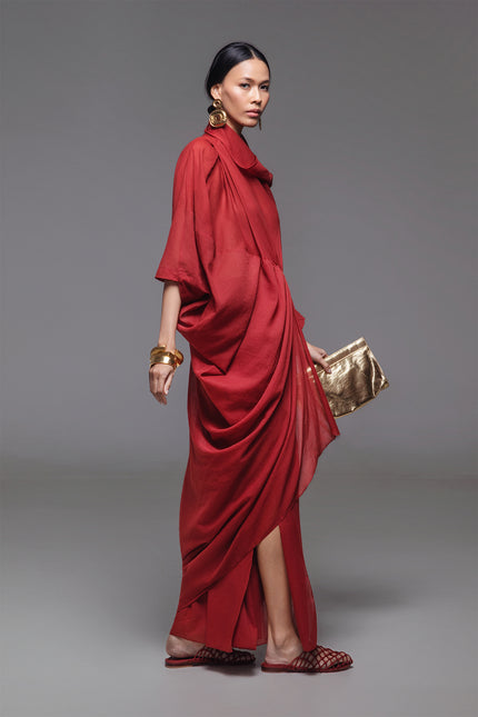 Model wearing Ozella Kaftan with contemporary silhouette, high neckline, sculptural drapery, and contrasting asymmetrical hem for a sophisticated look.