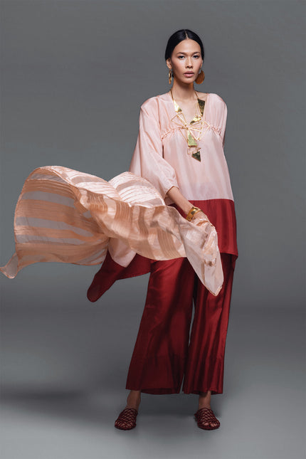 Model wearing Oretta Silk Tunic in lightweight silk, featuring a relaxed voluminous silhouette, square neckline, and adjustable drawstrings with a two-tone design.