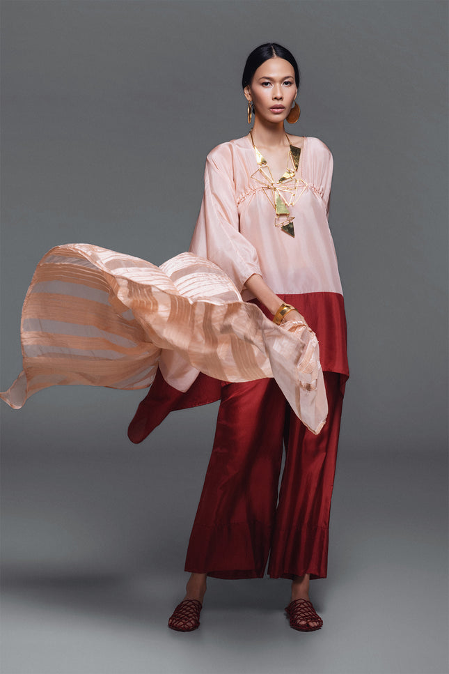 Model wearing Oretta Silk Tunic in lightweight silk, featuring a relaxed voluminous silhouette, square neckline, and adjustable drawstrings with a two-tone design.