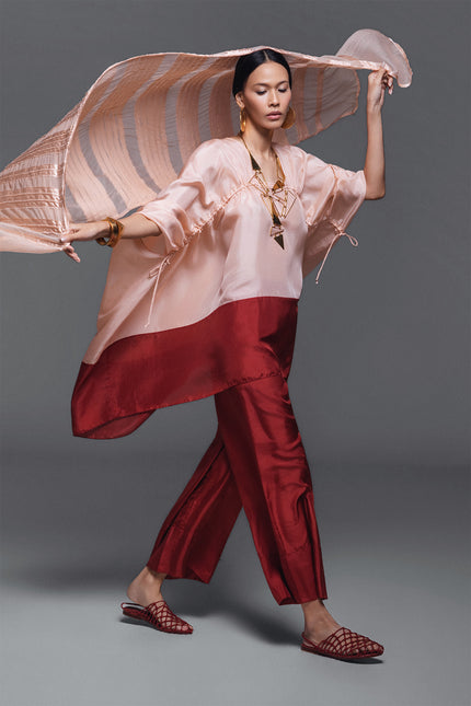 Model wearing Oretta Silk Tunic in lightweight silk, featuring a relaxed voluminous silhouette, square neckline, and adjustable drawstrings with a two-tone design.