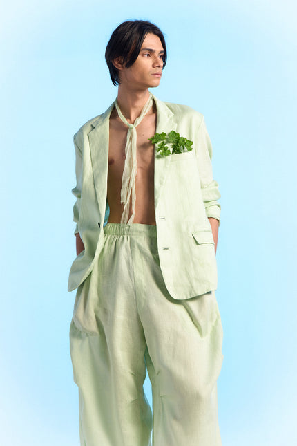 Model wearing Capri Jacket in 100% linen, featuring a slim silhouette, two-button front closure, subtle dotted edge stitching, curved hem, and buttoned cuffs.