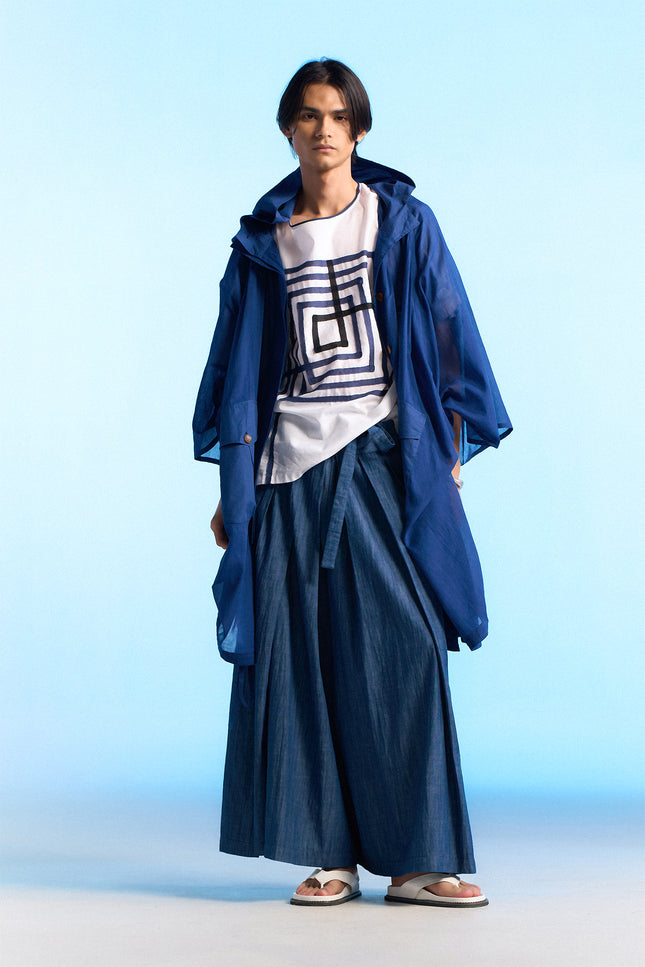 Model wearing the Nayeli Poncho with an oversized, hooded silhouette, featuring a hidden button opening and adjustable drawstring details that create a soft, flowing shape for modern everyday layering.