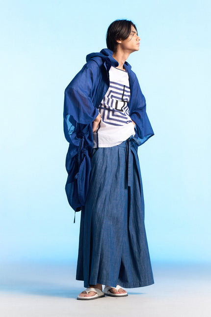 Model wearing the Nayeli Poncho with an oversized, hooded silhouette, featuring a hidden button opening and adjustable drawstring details that create a soft, flowing shape for modern everyday layering.